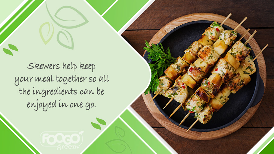 Bamboo skewers on a plate holding a selection of meats and vegetables