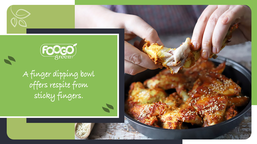 Hands holding sticky food, which a dipping bowl can be used to deal with